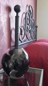 リミニにあるMamma Casa Superiorのベッド横のガラステーブルに置かれたガラスの花瓶