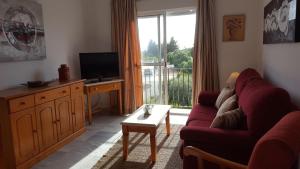 Televízia a/alebo spoločenská miestnosť v ubytovaní Apartamentos Saturnos