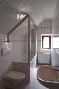 a bathroom with a tub and a toilet and a sink at Gaststätte Schwenksaal in Bayreuth