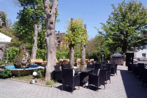 eine Reihe von Tischen und Stühlen in einem Park mit Bäumen in der Unterkunft Gaststätte Schwenksaal in Bayreuth