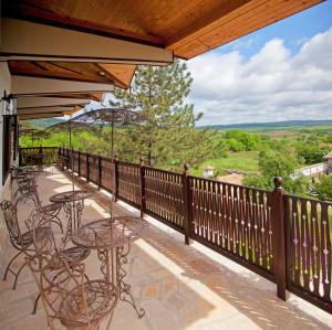 un patio con mesas y sillas en el balcón en Villa Bulgara Eco, en Madara