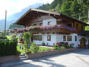 a house with flowers on the side of it at Landhaus Christophorus in Leogang