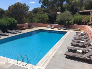 a swimming pool with lounge chairs next to it at Hotel Les Hauts de Porto-Vecchio in Porto-Vecchio