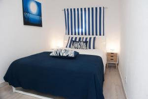 セジンブラにあるApartamento do Atlanticoのベッドルーム1室(大型ベッド1台、青い毛布付)