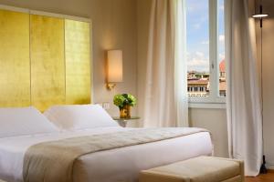 ein Schlafzimmer mit einem Bett und einem großen Fenster in der Unterkunft Grand Hotel Minerva in Florenz