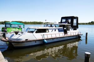 ein Boot an einem Dock auf dem Wasser angedockt ist in der Unterkunft House Boat Catamaran in Jabel