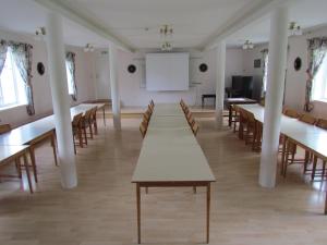 a large room with tables and chairs and a whiteboard at Olsnäsgården in Siljansnäs