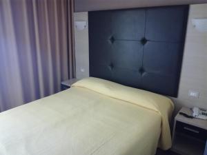 a bedroom with a bed with a blue headboard at Albergo Girasole Frontemare in San Benedetto del Tronto