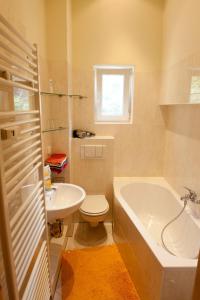 a bathroom with a tub and a toilet and a sink at Excellent Apartments Kreuzberg in Berlin