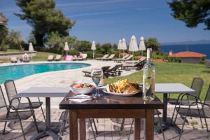 a table with a bowl of food and a bottle of wine at Alkion Hotel in Kriopigi