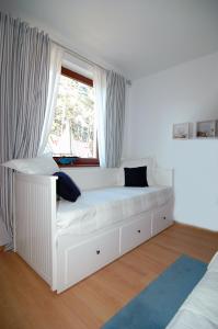 ウケンチンにあるNadmorski Domekの窓付きの客室の白いベッド1台