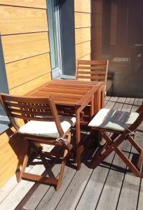 a wooden table and two chairs on a porch at Žiogų apartamentas in Palanga