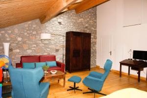 a living room with blue chairs and a piano at Moulin d'entre les roches in Puivert