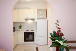a kitchen with white appliances and a white refrigerator at Apartments Beautiful Sandy Beach in Split