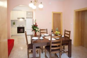 a kitchen and dining room with a wooden table and chairs at Apartments Beautiful Sandy Beach in Split