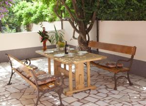 a wooden table with two chairs and a bench at Apartments Beautiful Sandy Beach in Split
