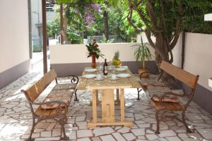 a wooden table and chairs on a patio at Apartments Beautiful Sandy Beach in Split
