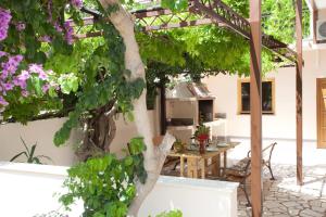 a patio with a table and a tree with flowers at Apartments Beautiful Sandy Beach in Split