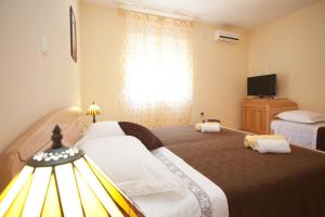 a hotel room with two beds and a window at Apartments Beautiful Sandy Beach in Split