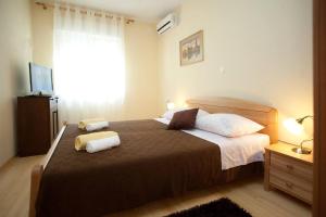 a bedroom with a bed with two towels on it at Apartments Beautiful Sandy Beach in Split