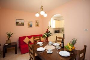 a living room with a table and a red couch at Apartments Beautiful Sandy Beach in Split
