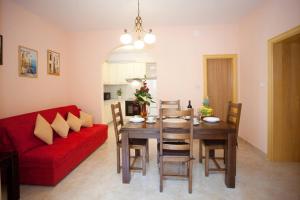 a living room with a table and a red couch at Apartments Beautiful Sandy Beach in Split