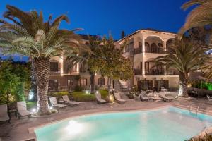 a resort with a swimming pool and palm trees at Villa Pipini Luxury Studios in Limenas