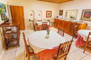 a dining room with two tables and a kitchen at Bay Tree Guest House in Pretoria