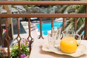 two glasses of orange juice sitting on a table on a balcony at Villa Pipini Luxury Studios in Limenas