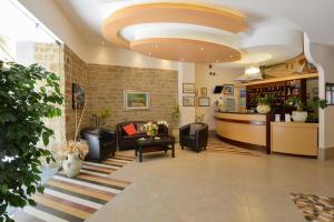 una hall con divano, sedie e bar di Hotel La Pergola a Santa Maria di Castellabate
