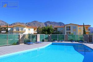a swimming pool in front of some houses at Monachus Monachus in Frangokastello