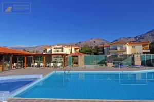 a swimming pool in front of some houses at Monachus Monachus in Frangokastello