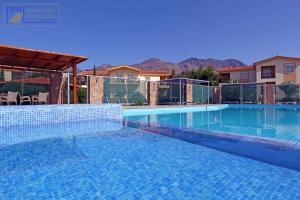 a swimming pool in a villa with mountains in the background at Monachus Monachus in Frangokastello