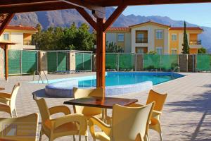 a patio with a table and chairs and a swimming pool at Monachus Monachus in Frangokastello