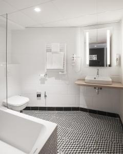 a bathroom with a tub and a sink and a toilet at ibis Styles Laval Centre Gare in Laval +64 photos
