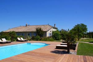 un patio trasero con piscina y una casa en Le Domaine des Doucins & Spa, Gîte 4 étoiles, 10 minutes de Jonzac piscine et spa, en Fontaines-dʼOzillac