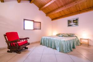 カステッランマーレ・デル・ゴルフォにあるCasale Dei Gelsiのベッドルーム(赤い椅子、ベッド付)