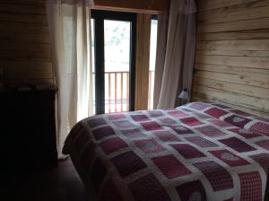 1 dormitorio con 1 cama con edredón en La Meiro, en Castelmagno