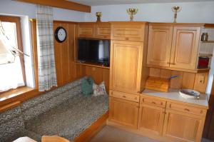 a room with a couch in a kitchen with a clock at Rieplerhof in Matrei in Osttirol