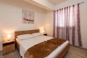 a bedroom with a large bed and a window at Apartments Robi in Trogir