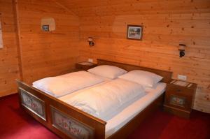 a bed in a wooden room with two pillows at Rieplerhof in Matrei in Osttirol
