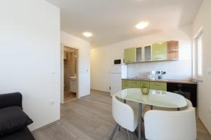 a kitchen with a table and chairs in a room at Apartments Robi in Trogir