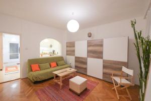 un soggiorno con divano e tavolo di Vince apartman a Pécs