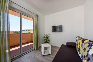 a living room with a couch and a large window at Apartments Robi in Trogir