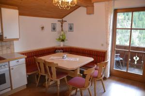 a kitchen with a wooden table and chairs and a window at Rieplerhof in Matrei in Osttirol