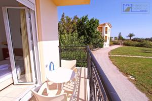 a balcony of a house with a table and chairs at Monachus Monachus in Frangokastello