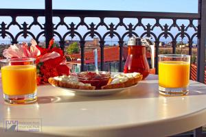 a table with two glasses of orange juice and a plate of food at Monachus Monachus in Frangokastello