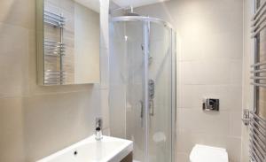 a white bathroom with a shower and a sink at The Wesley in York