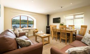 a living room with a couch and a dining room at Hill Of Oaks in Windermere