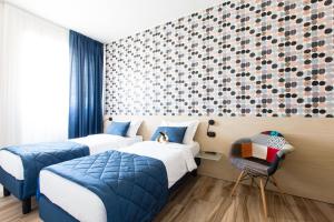um quarto de hotel com duas camas e uma cadeira em Aparthotel Isola em Milão